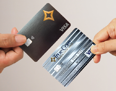 Hands holding a Visa Cashback Rewards card and a Visa Platinum credit card.