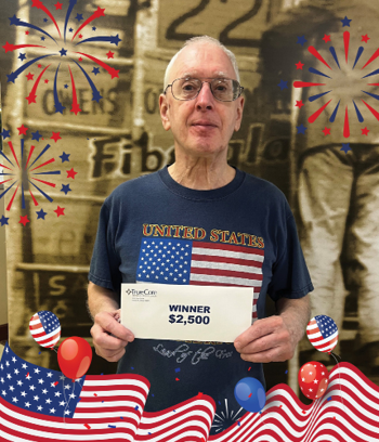 Senior man holding an envelope that says Winner $2,500.